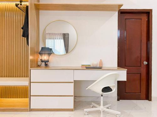 a desk with a mirror and a chair in a room at Click Residence, Si Muang in Vientiane