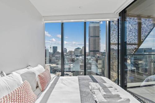 a bedroom with a bed and a view of a city at One bedroom apartment in the heart of CBD in Adelaide