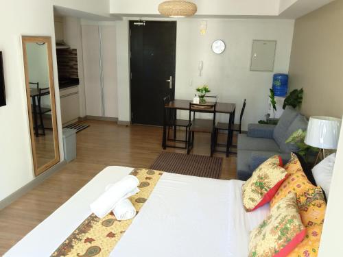 a room with a bed and a living room at Cozy & Stylish Stay - Abreeza Mall - Pool - WiFi - T2-2312 in Davao City