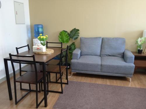 a living room with a table and a couch at Cozy & Stylish Stay - Abreeza Mall - Pool - WiFi - T2-2312 in Davao City