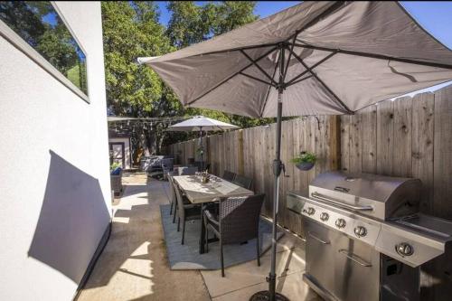 a patio with a table with an umbrella and a stove at Large Hot Tub! Family Friendly - Stylish and Cozy in Canyon Lake