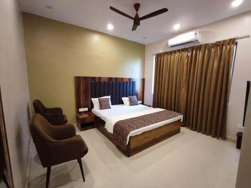 a bedroom with a bed and two chairs in it at Mishka Boutique Hotel in Rāmgarh