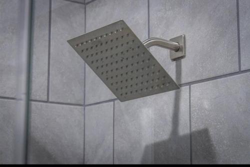a metal shower head in a shower stall at Large Hot Tub! Family Friendly - Stylish and Cozy in Canyon Lake