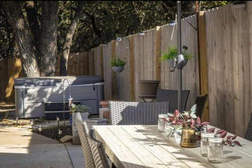 a wooden table in a backyard with a fence at Large Hot Tub! Family Friendly - Stylish and Cozy in Canyon Lake