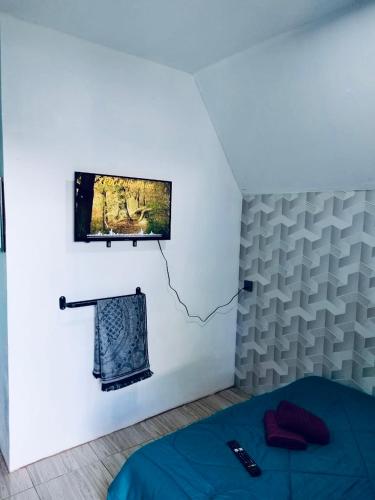 a bedroom with a bed and a tv on the wall at Roomstay Wadihana in Yan