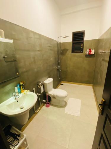 a bathroom with a toilet and a sink at Ceylon Avenue in Habaraduwa