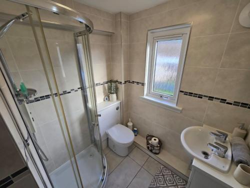 a bathroom with a shower and a toilet and a sink at Pannanich View Cottage, Ballater in Ballater