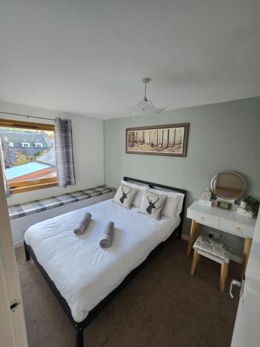 a bedroom with a bed with two pillows on it at Pannanich View Cottage, Ballater in Ballater