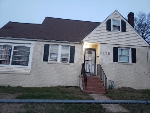 a white house with a door and a fence at Unit-A Gorgeous private suite near metro train station and Washington DC in Capitol Heights