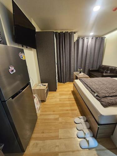 a small room with a bed and a refrigerator at forest by Bangboon by Parisa in Sathani Wat Sing