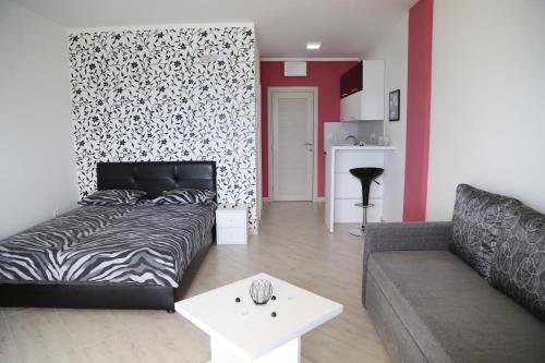 a living room with a bed and a couch at Apartments Piano in Utjeha