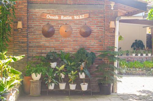 a brick wall with a bunch of potted plants at Omah Ralin Family Homestay with Spacious Joglo House in Timuran
