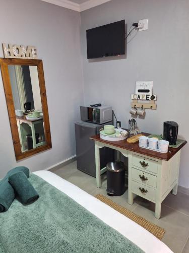 a room with a table and a mirror and a desk with a microwave at The Guestroom in Klerksdorp