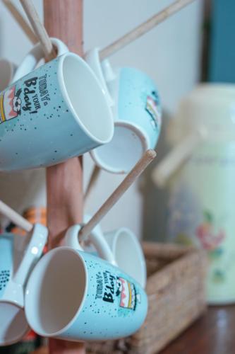a bunch of coffee cups hanging from a rack at Hostel Singha Lounge in Unawatuna