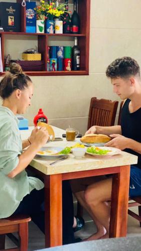 two people sitting at a table eating food at Bong House Homestay 2 in Hoi An