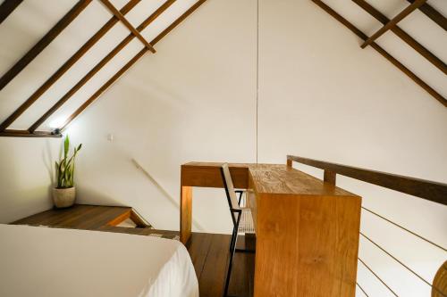 a room with a bed and a wooden table at Suksma Guesthouse in Canggu
