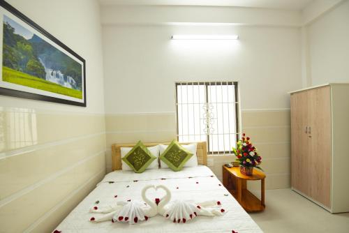 a bedroom with two beds with white sheets and a window at Bong House Homestay 2 in Hoi An