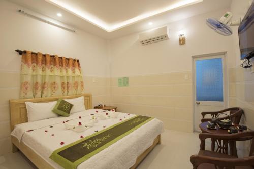 a bedroom with a bed with flowers on it at Bong House Homestay 2 in Hoi An