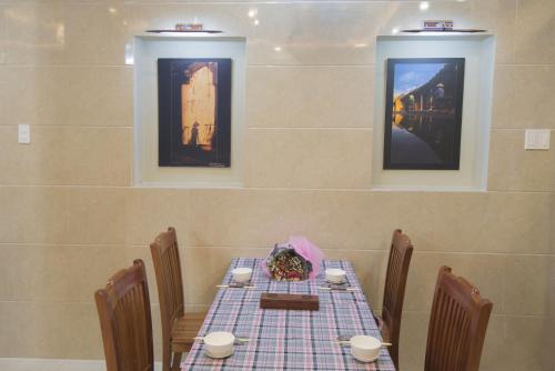 a dining room with a table with a blue checkered table cloth at Bong House Homestay 2 in Hoi An