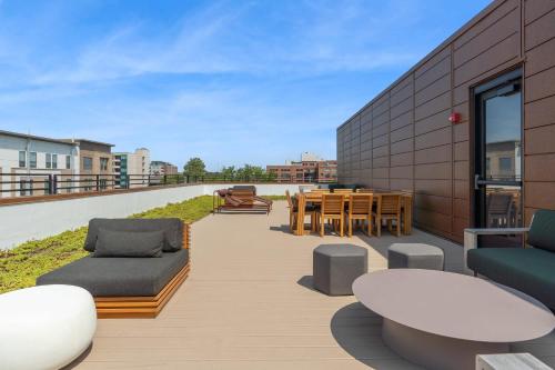 a patio with tables and chairs on a building at CozySuites Mass with parking lounge & roof deck #24 in Indianapolis