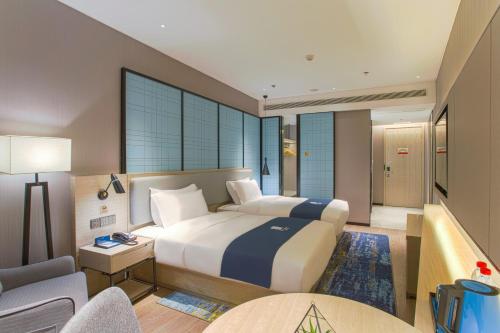 een hotelkamer met een groot bed en een bank bij Echarm Hotel Liudong Wuling Liuqi Of Liuzhou in Luorong