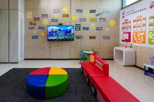 a room with a toy train and a tv at Holiday Garden Hotel SKM Park in Kaohsiung