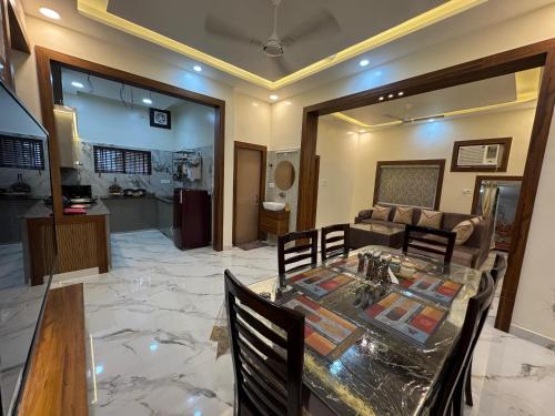 a dining room with a table and chairs and a kitchen at Ganga Bliss in Haridwār