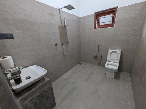 a bathroom with a sink and a toilet at Costels Mirissa in Mirissa