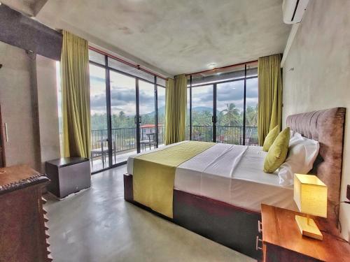 a bedroom with a large bed and a large window at Catch Up Dambulla in Dambulla