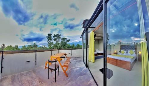 a balcony with a bedroom and a bed and a table at Catch Up Dambulla in Dambulla