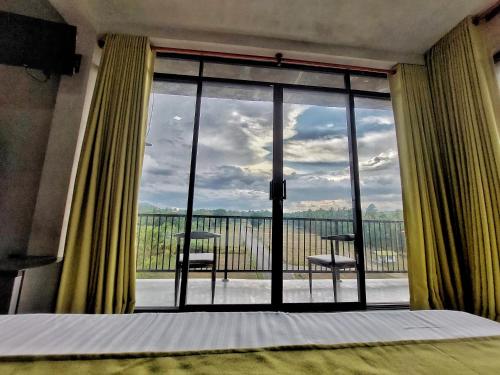 a bedroom with a bed and a large glass window at Catch Up Dambulla in Dambulla