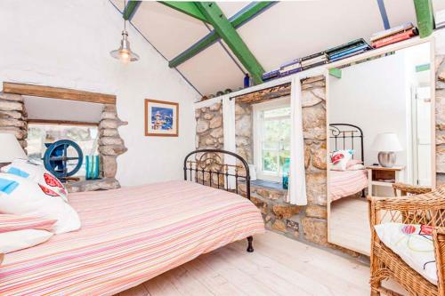Un dormitorio con dos camas con un tren en la pared. en Castaways, Cottage With Sea Views, Lush Gardens & Patio By the Beach, en Sennen