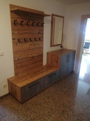 a room with a wooden wall and a vanity with a mirror at Haus-Elisabeth in Uderns