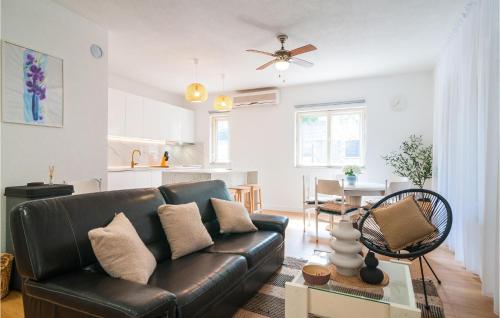 スペタルにあるAwesome Home In Supetar With Wifiのリビングルーム(黒い革張りのソファ付)、キッチン