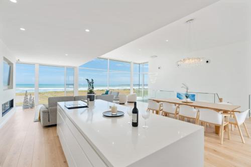 a white kitchen and dining room with a view of the ocean at Casa Bianca 50 Esplanade Middleton - Linen Included in Middleton