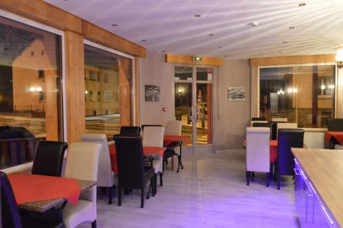 uma sala de jantar com mesas e cadeiras num restaurante em Hôtel Timgad em Gérardmer