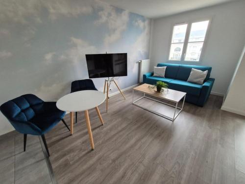 un salon avec un canapé bleu et une télévision dans l'établissement Disneyland Sky Haven - 5min to Disneyland, à Serris