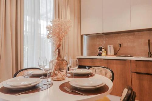 - une table avec des assiettes, des verres à vin et un vase dans l'établissement Angleterre 1 - Nice Centre - 2 pièces Terrasse, à Nice