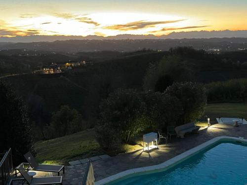 a villa with a swimming pool at sunset at Splendid Villa Magna with Pool and Park - Langhe Hills in Govone