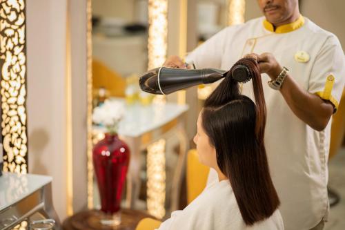 a woman getting her hair cut by a barber at The Imperial, New Delhi in New Delhi