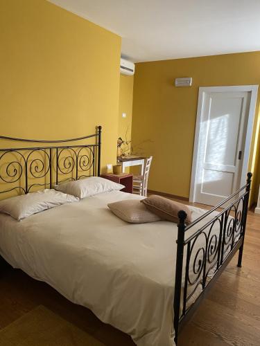 a large bed in a room with a yellow wall at B&B MELLONI STREET in Dolo