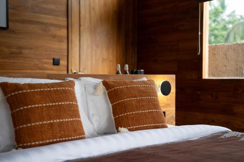 a bedroom with a bed with brown and white pillows at Kini Sebatu in Tampaksiring