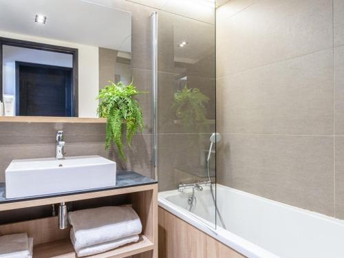 une salle de bain avec un lavabo, une baignoire et un miroir dans l'établissement Appartement de luxe calme Les Saisies - 6 pers, SPA & parking privé - FR-1-810-3, à Hauteluce
