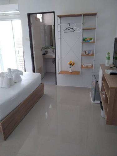 a white bedroom with a bed and a bathroom at 07 Antalya Boutique Hotel in Patong Beach