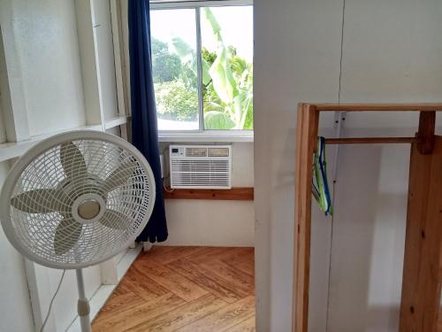 a fan in a room with a window at Christina's Guest House OFFICIAL in Little Corn Island