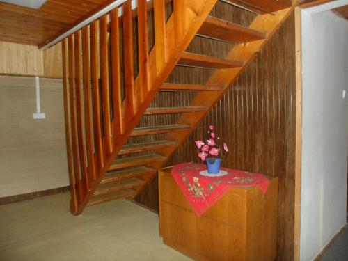 a wooden staircase with a vase of flowers on a table at Pension Mikulka in Mikulov v Krušných Horách