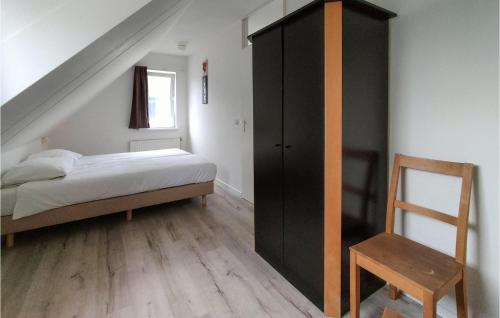 a bedroom with a bed and a black cabinet at Lovely Home In Vlagtwedde With Kitchen in Vlagtwedde