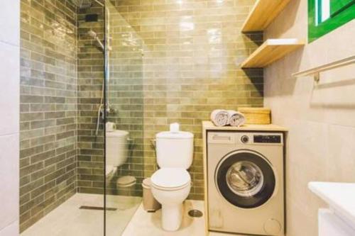 a bathroom with a toilet and a washing machine at Casa Roma in Puerto del Carmen