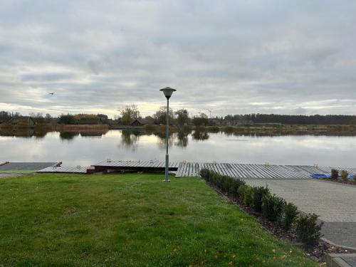 a dock on a lake with a light on the grass at Marina Wolin in Wolin