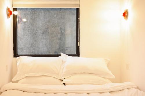 a bedroom with a bed with white pillows and a window at 三宝院子 in Jingdezhen